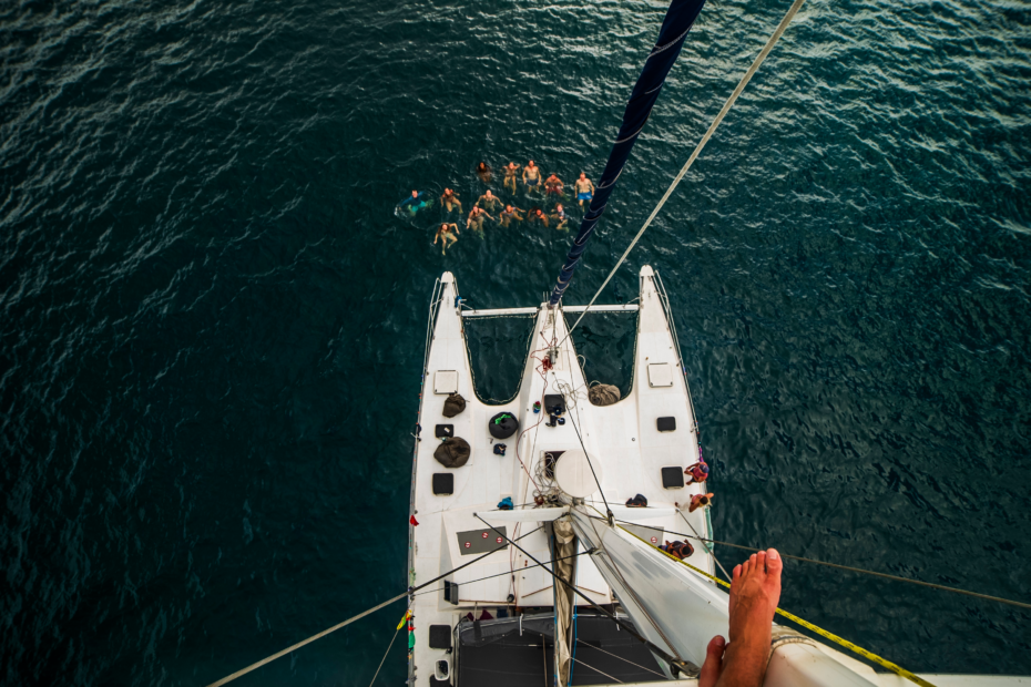 Photot taken from mast of sailboat of 15 people swimming in the water on a sailing trip from Colombia to panama. What's the cost of sailing from colombia to panama?