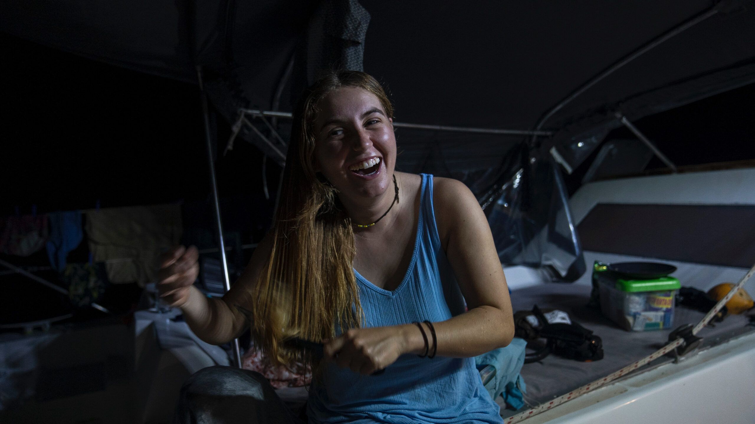 Woman laughing while combing hair on a sailboat sailing from colombia to panama