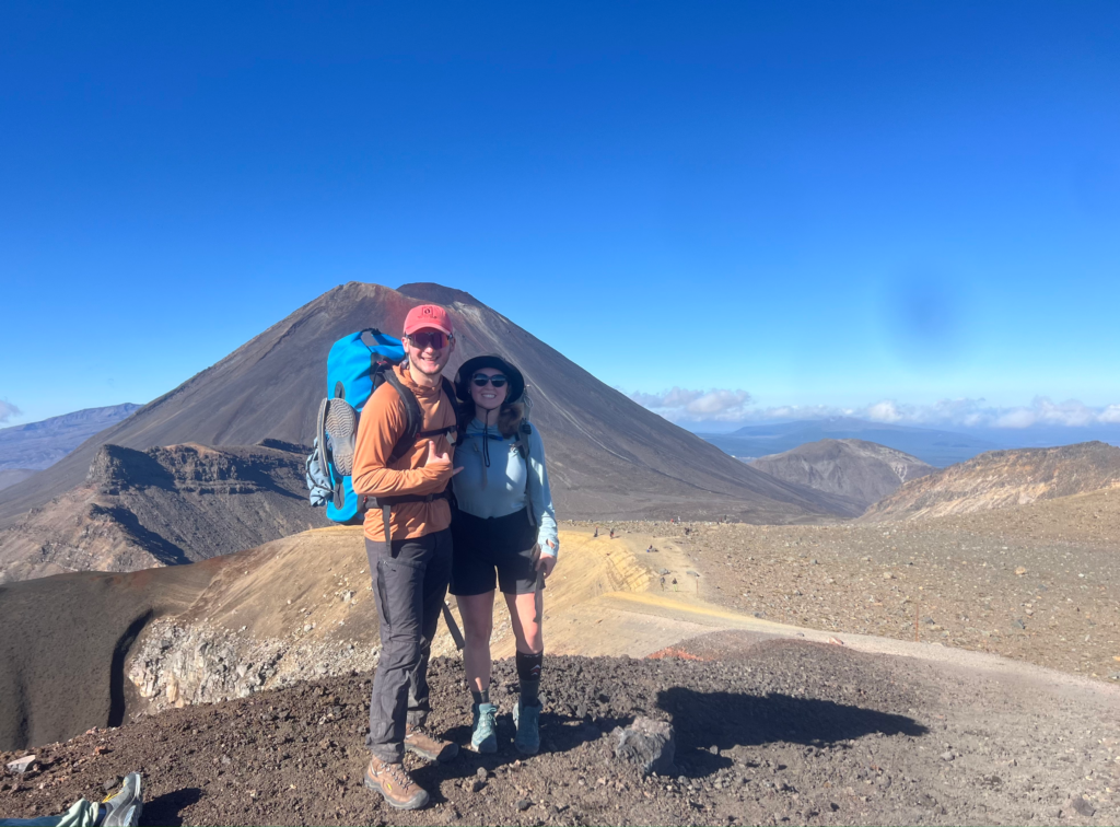 Happy man and woman couple standing in front of Mt. Ngauruhoe volcano in tongariro national park
