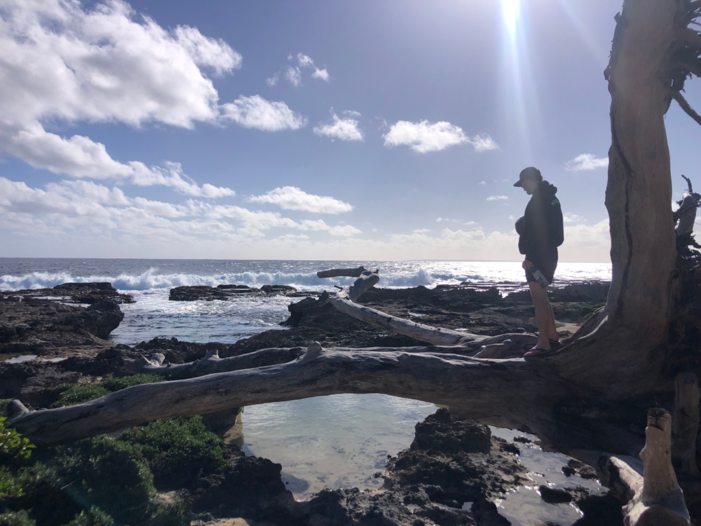 the beaches on 'Eua are volcanic with lots of tide pools, man standing on lava rock