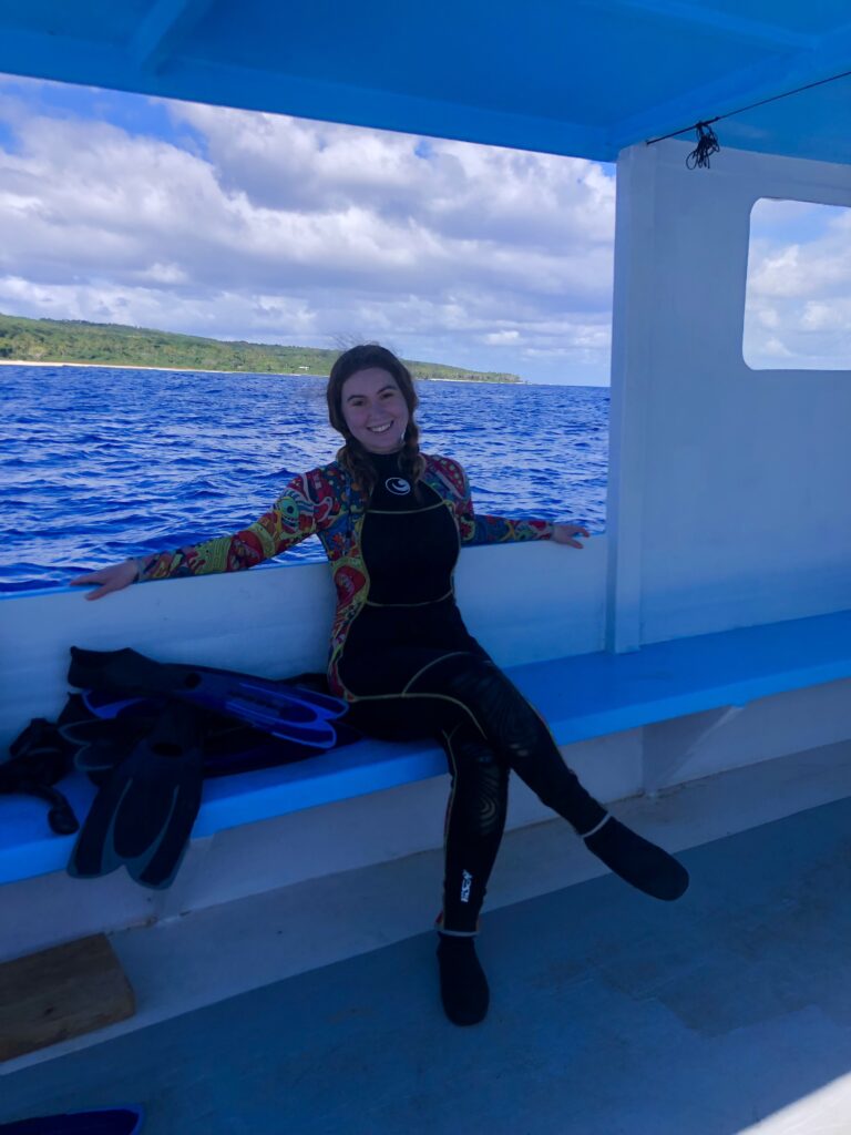 On a whale swim in Tonga. A smiling woman in a wetsuit sitting on a small boat