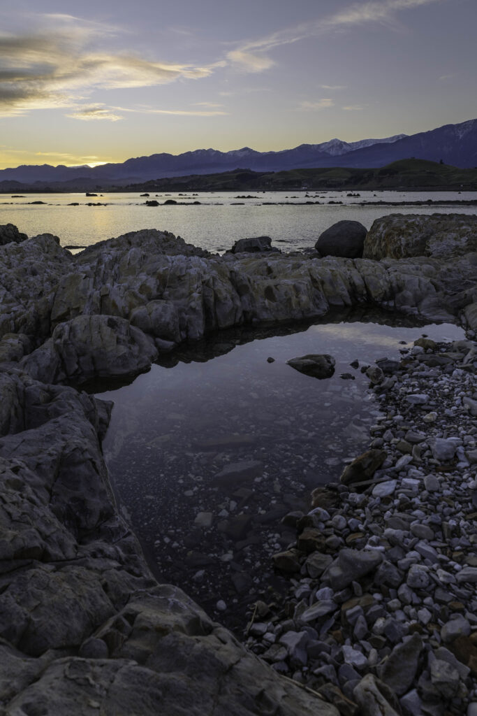 how to spend 2 days in kaikoura, head to the beach! Rocky intertidal beach at sunset