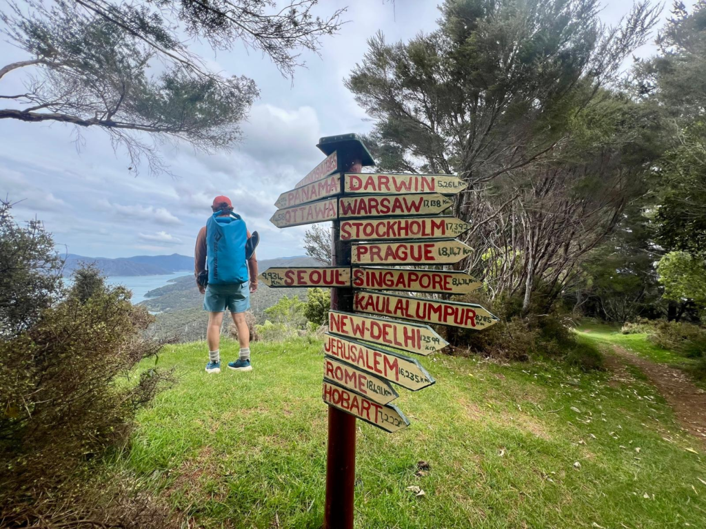 sign post shpwing distances to other countries on the queen charlotte track hike