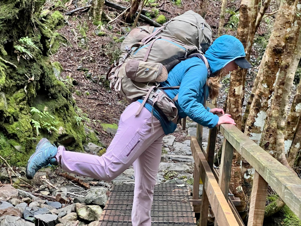 woman on heaphy track looking over the side of a bridge